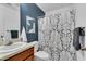 Cozy bathroom with a navy blue wall, a shower with a patterned curtain, and a sink with a wooden cabinet at 4600 Townesbury Ln, Raleigh, NC 27612