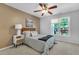 Comfortable bedroom with a ceiling fan, a window, and a side table with a lamp at 4600 Townesbury Ln, Raleigh, NC 27612