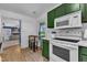 Well-equipped kitchen with updated appliances, green cabinets, and an adjacent breakfast nook at 4600 Townesbury Ln, Raleigh, NC 27612