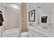 Cozy bathroom showcasing a shower over tub, patterned curtain, and white vanity with modern fixtures at 5032 Jowetts Walk Dr # 26, Cary, NC 27519