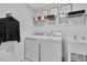 A modern laundry room featuring a washer, dryer, sink, and shelving at 5032 Jowetts Walk Dr # 26, Cary, NC 27519