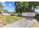 Exterior view showing the backyard, detached garage, and gravel driveway at 506 W Walnut St, Selma, NC 27576