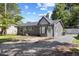 Single-story home with a gray exterior, gravel driveway, and manicured front lawn on a sunny day at 506 W Walnut St, Selma, NC 27576