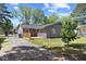 Exterior view of home showcasing the back deck, tidy lawn and gravel driveway at 506 W Walnut St, Selma, NC 27576