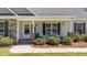 Inviting front porch features a seating area, brick columns, and well manicured landscaping at 509 Par Dr, Nashville, NC 27856
