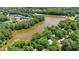 The aerial view highlights the community lake and the house nestled among green trees at 5320 Middleton Rd, Durham, NC 27713