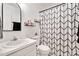 Modern bathroom featuring geometric shower curtain, floating shelves and a mirrored vanity area at 5320 Middleton Rd, Durham, NC 27713