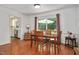 Cozy dining room featuring wood floors, a wooden table with four chairs, and sliding glass doors to the backyard at 5320 Middleton Rd, Durham, NC 27713