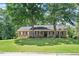 Classic brick home with black shutters and a welcoming front porch framed by mature trees at 5320 Middleton Rd, Durham, NC 27713