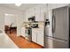 Kitchen with stainless steel appliances, white cabinets, and hardwood floors that open to the dining area at 5320 Middleton Rd, Durham, NC 27713