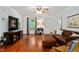 Cozy living room features hardwood floors, a leather sofa, and a large window for natural light at 5320 Middleton Rd, Durham, NC 27713