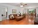 A comfortable living room with hardwood floors, a leather sofa, and access to the dining area at 5320 Middleton Rd, Durham, NC 27713