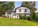 Charming two-story white brick home with black trim, well-manicured lawn, and lush landscaping at 5400 Kaplan Dr, Raleigh, NC 27606