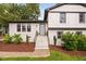 Well-maintained white brick home featuring landscaped front yard, brick steps, and charming blue door at 5400 Kaplan Dr, Raleigh, NC 27606