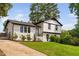 Inviting white brick home with lush landscaping, complemented by mature trees and a charming driveway at 5400 Kaplan Dr, Raleigh, NC 27606