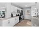 Bright kitchen with white cabinets, stainless steel appliances, granite countertops, and wood-look flooring at 5400 Kaplan Dr, Raleigh, NC 27606