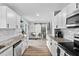 Clean kitchen with white cabinetry and granite countertops extending to a dining area with access to the backyard at 5400 Kaplan Dr, Raleigh, NC 27606