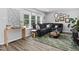 Stylish living room featuring a comfortable blue sectional sofa, wood floors, and abundant natural light from large windows at 5400 Kaplan Dr, Raleigh, NC 27606