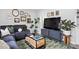 Cozy living room with a gray sofa, modern coffee table, a large TV, and gallery wall, perfect for relaxing at 5400 Kaplan Dr, Raleigh, NC 27606