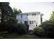View of the back of this charming two-story home with mature trees and green grass at 6229 Saybrooke Dr, Raleigh, NC 27604