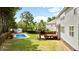 View of the backyard pool and shed, surrounded by lush greenery and mature trees at 626 Toledo Ct, Rolesville, NC 27571