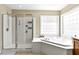 Bright bathroom with a glass shower and an elevated soaking tub at 626 Toledo Ct, Rolesville, NC 27571
