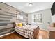 Comfortable bedroom featuring plank accent wall, hardwood floors, and natural light at 626 Toledo Ct, Rolesville, NC 27571