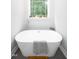 Relaxing bathroom featuring a freestanding tub under a window with a wooded view at 698 Maple Springs Ln, Bear Creek, NC 27207
