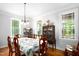 Formal dining room with a large table, wood floors, classic china cabinet, and large windows offering lots of natural light at 698 Maple Springs Ln, Bear Creek, NC 27207