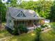 Charming home featuring a covered front porch, beautiful landscaping, and a lush, wooded surrounding at 698 Maple Springs Ln, Bear Creek, NC 27207