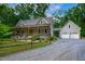 Charming home featuring a cozy front porch, well-maintained landscaping and a detached garage at 698 Maple Springs Ln, Bear Creek, NC 27207