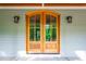 Up close view of the front door with beautiful stained wood and decorative carriage lights at 698 Maple Springs Ln, Bear Creek, NC 27207