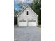 Attached two-car garage with white doors and modern lighting fixture at 698 Maple Springs Ln, Bear Creek, NC 27207
