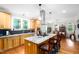 Spacious kitchen with island and bar stool seating plus light wood cabinetry, granite counters and stainless appliances at 698 Maple Springs Ln, Bear Creek, NC 27207