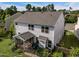 Two-story home's backyard featuring a screened porch, patio, grill, and lush, green lawn on a sunny day at 7 Faircroft Ct, Durham, NC 27703