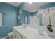 Bright bathroom with a white vanity, light blue walls, and a large mirror at 7 Faircroft Ct, Durham, NC 27703