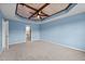 Spacious bedroom with tray ceilings, ceiling fan, neutral carpet, and light blue walls at 7 Faircroft Ct, Durham, NC 27703