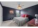 Comfortable bedroom with a ceiling fan, natural light, and dark-colored walls at 7 Faircroft Ct, Durham, NC 27703