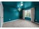 Stylish bedroom with elegant chandelier, large window, neutral carpet, and calming blue walls at 7 Faircroft Ct, Durham, NC 27703