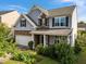 Two-story home with stone accents, a two-car garage, and professionally landscaped yard at 7 Faircroft Ct, Durham, NC 27703