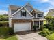 Two-story home with a two-car garage, stone accents, and a well-manicured lawn on a sunny day at 7 Faircroft Ct, Durham, NC 27703