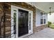 Close up of a black front door framed by white trim, stone accents, and a sidelight window at 7 Faircroft Ct, Durham, NC 27703