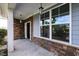 View of the front door framed by stone accents, a sidelight window, and an overhead lantern at 7 Faircroft Ct, Durham, NC 27703