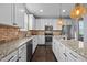 Modern kitchen featuring white cabinets, granite countertops and backsplash, and an island at 7 Faircroft Ct, Durham, NC 27703