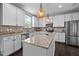 Bright kitchen with granite countertops, a kitchen island, and stainless steel appliances at 7 Faircroft Ct, Durham, NC 27703