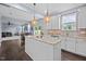 Open concept kitchen with island and granite countertops that connect to a bright living space at 7 Faircroft Ct, Durham, NC 27703