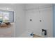 A dedicated laundry room featuring white walls, shelving, and nearby living room at 7 Faircroft Ct, Durham, NC 27703