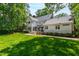 This well-maintained backyard showcases a spacious lawn, mature trees, and a charming home exterior at 7620 Rainwater Rd, Raleigh, NC 27615