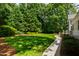 A lush green backyard features manicured landscaping and a charming walking path at 7620 Rainwater Rd, Raleigh, NC 27615