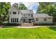 A spacious backyard showcases a charming white home with a large deck and stairs at 7620 Rainwater Rd, Raleigh, NC 27615